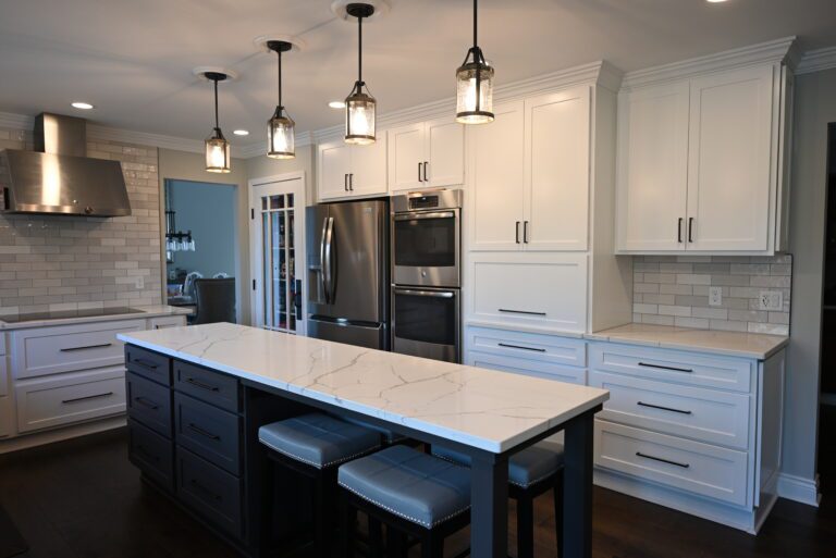 White kitchen with a dark island and quartz counters