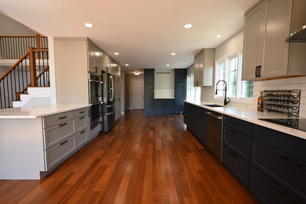 Open-concept kitchen with an island, hardwood floors, and a rebuilt staircase after a whole-home renovation