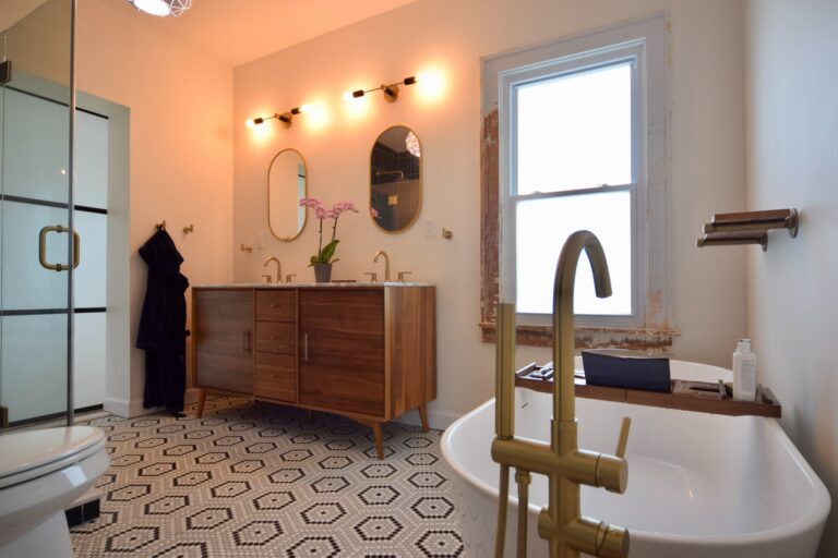 Double vanity with arched mirrors and dark wood cabinets