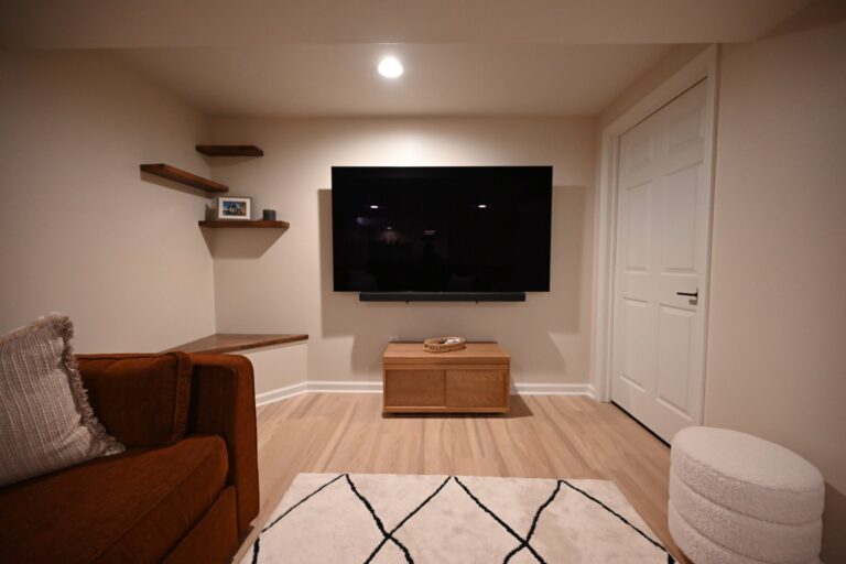 Basement media wall with a mounted TV and floating shelves