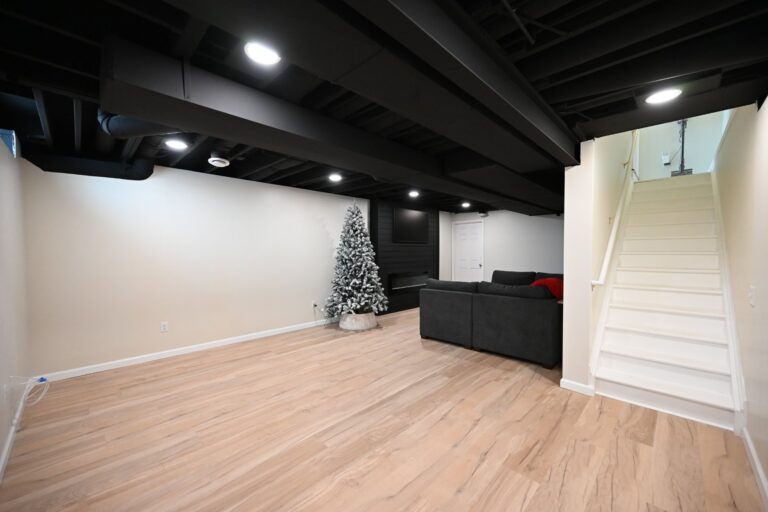 Finished basement rec room with staircase and gallery wall