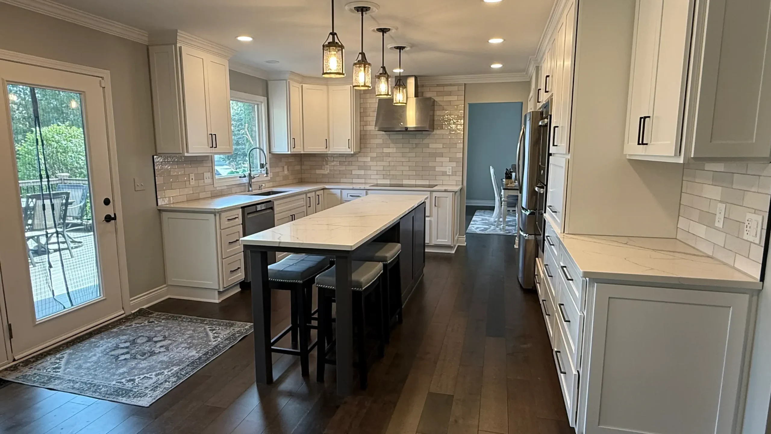 The Darwood Kitchen - Complete renovation featuring custom white cabinetry, navy island, and pendant lighting