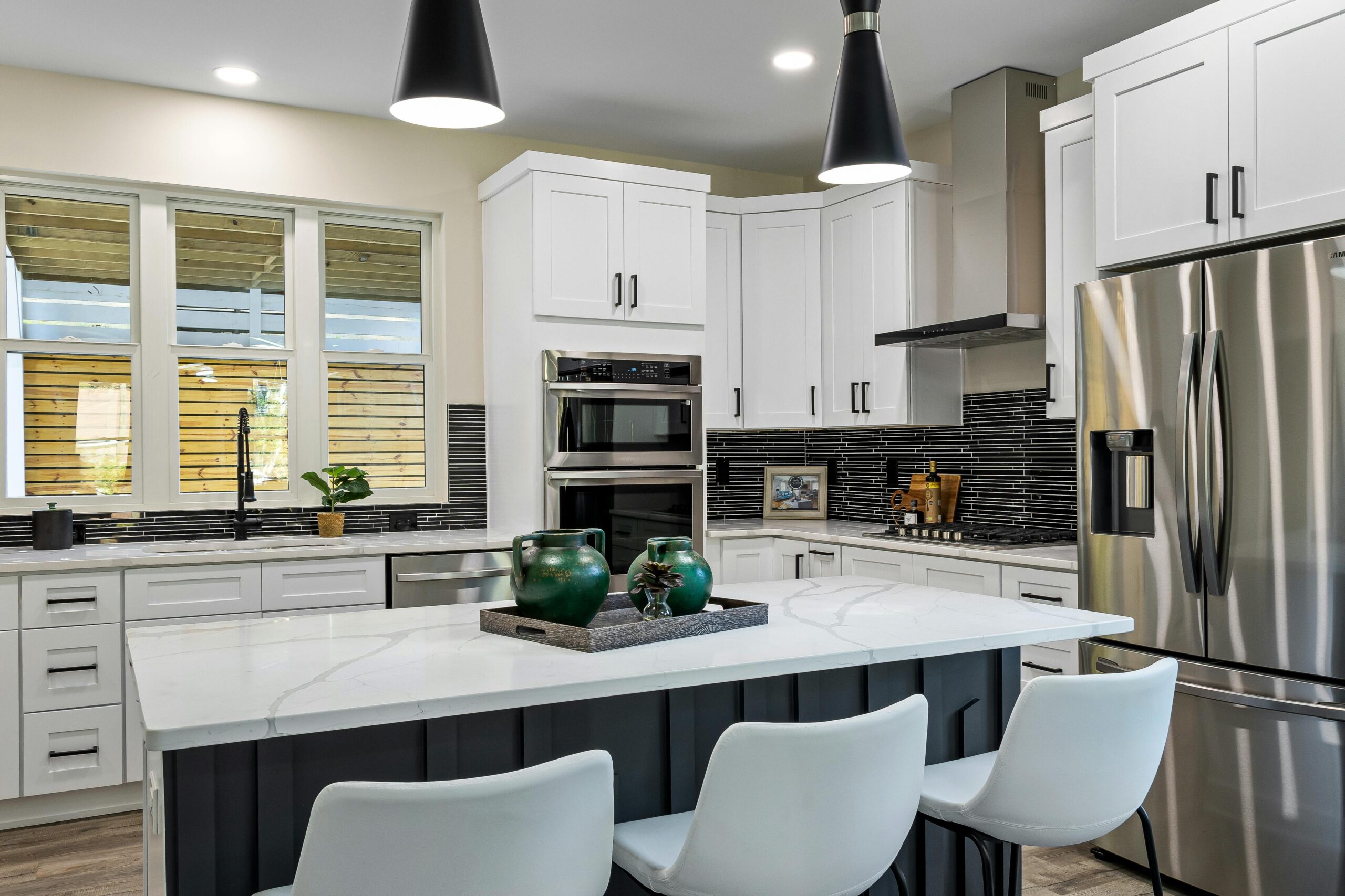 A remodeled open-concept kitchen with a large island, warm wood cabinets and quartz countertops.