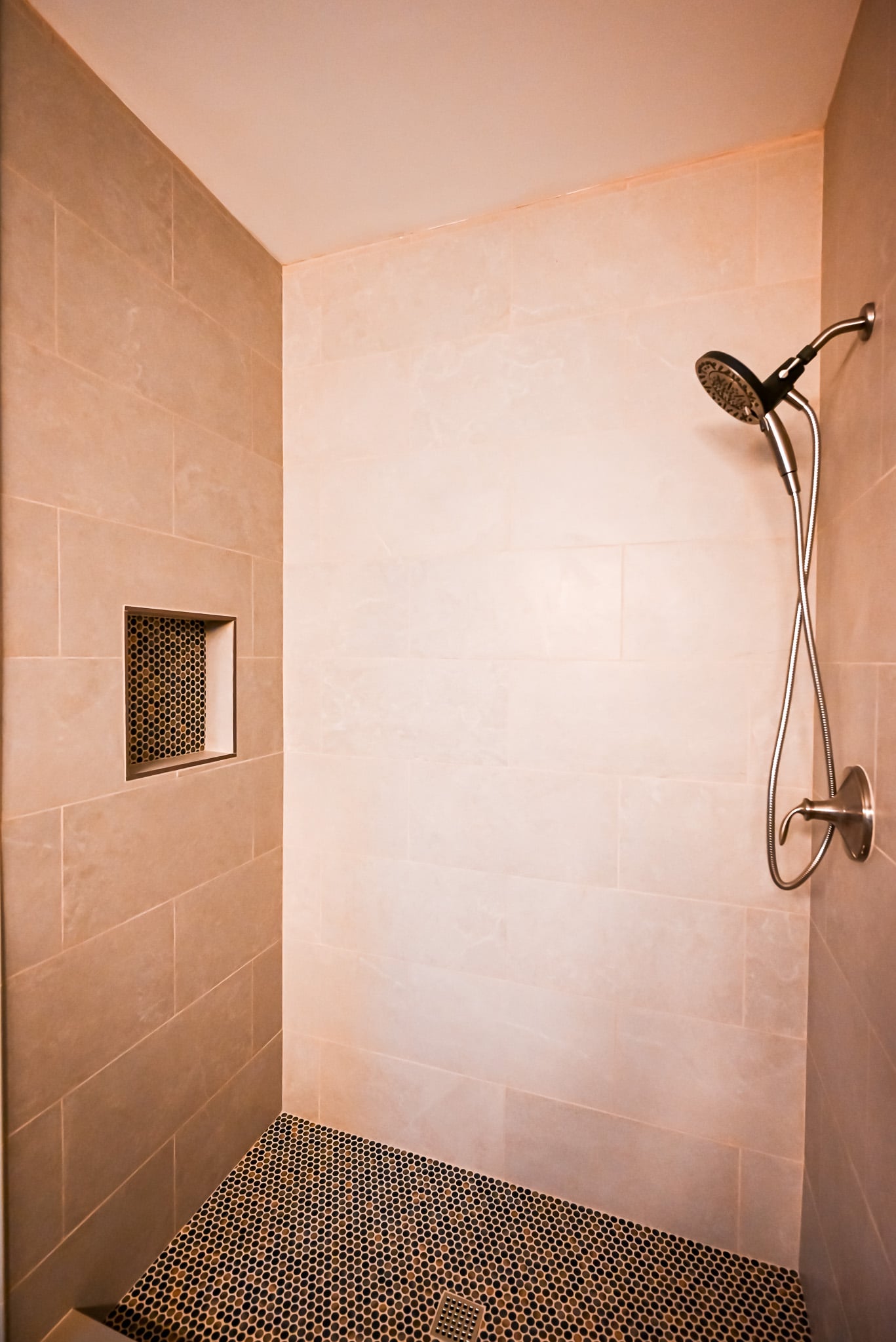 Walk-in shower from a second angle showing full tile walls extending to the ceiling
