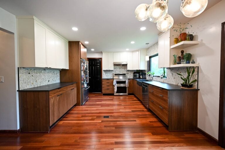 Open concept remodeled kitchen in Ann Arbor with wood cabinets, black counters and hardwood floors