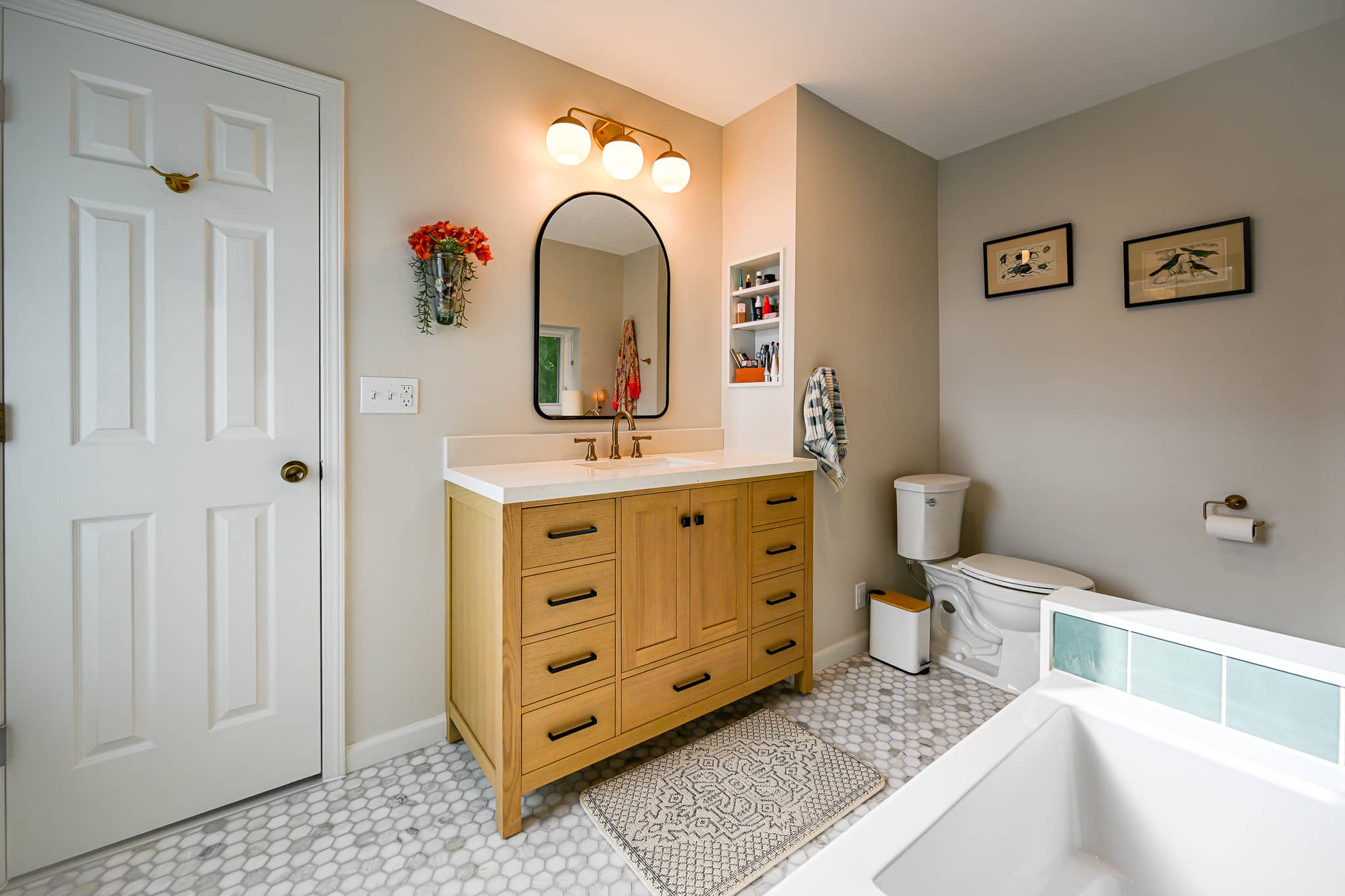 Vanity and toilet on the white marble hexagon floor with warm neutral walls in the Dexter bathroom