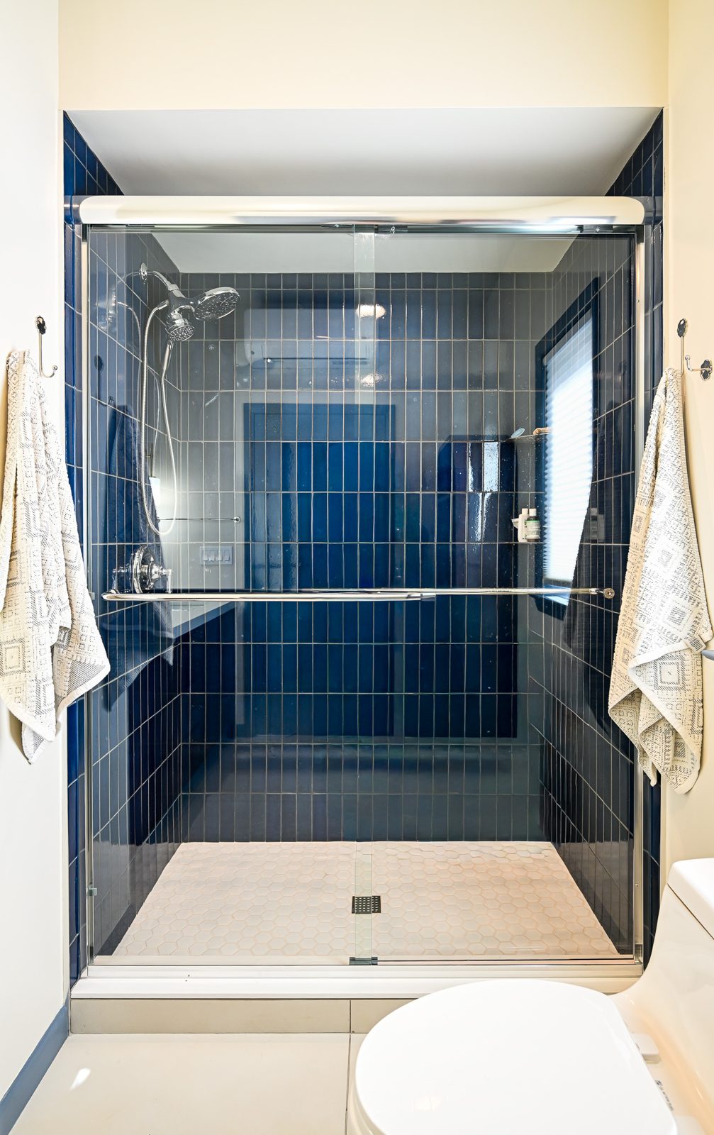 Walk-in shower with blue tile in the new suite over the garage