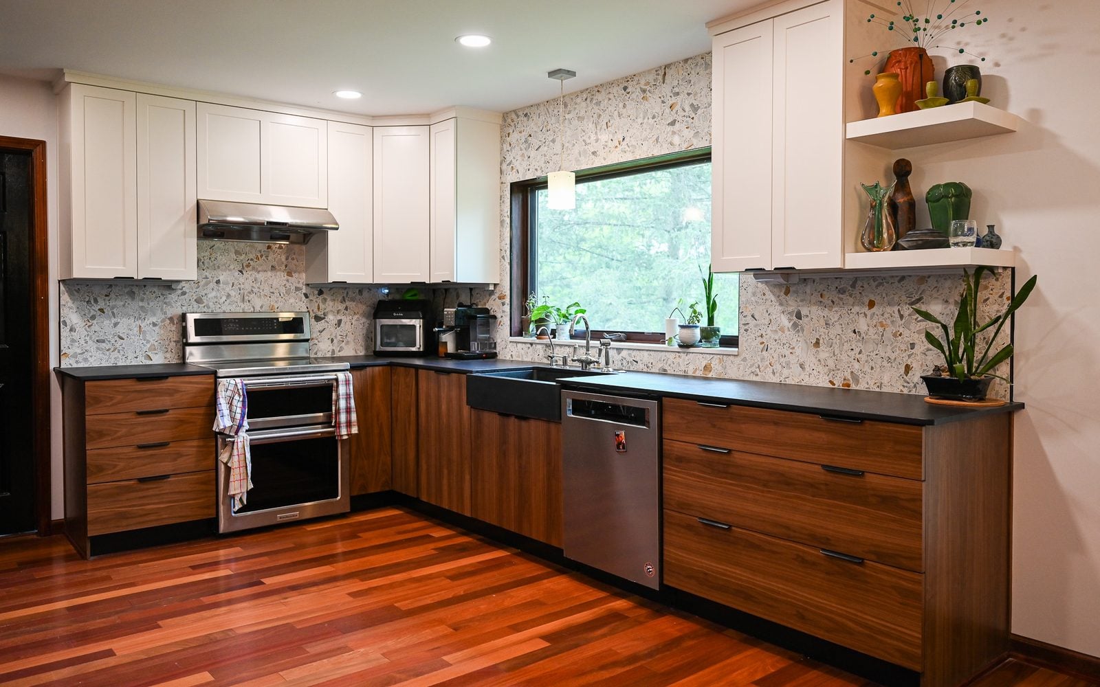 Remodeled Ann Arbor kitchen with walnut slab base cabinets, white shaker wall cabinets, a terrazzo backsplash and matte black counters