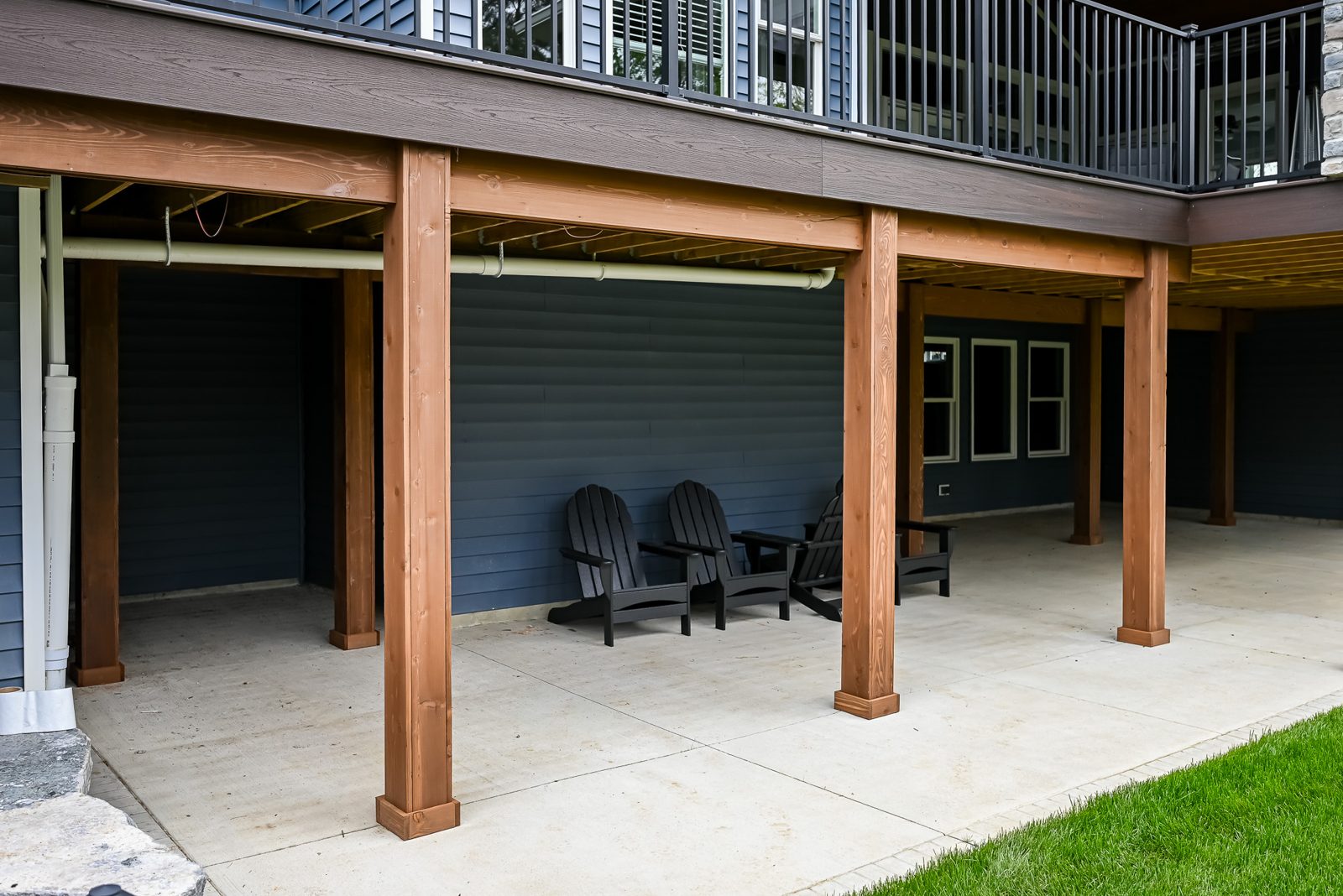Cedar-wrapped posts framing a shaded patio beneath an Ann Arbor deck