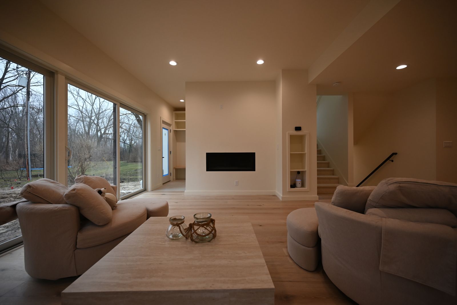 Great room with a linear fireplace and wide windows in the Ann Arbor addition