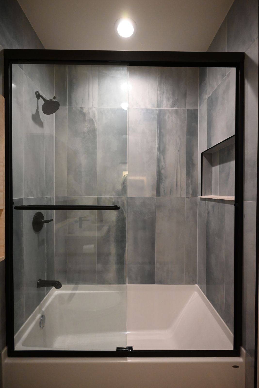 Updated bathroom with a tub and glass shower surround in the Ann Arbor remodel