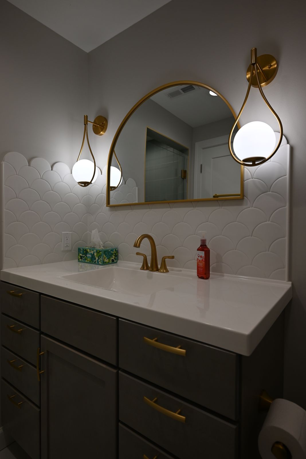 New bathroom vanity with gold fixtures and scalloped tile in the Ann Arbor home