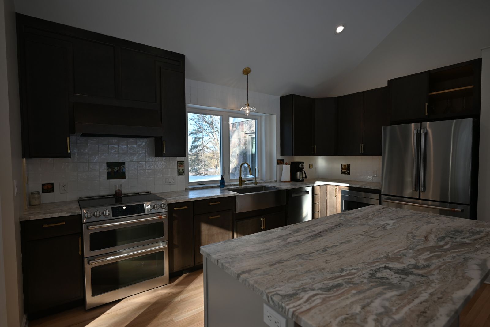 Remodeled kitchen with dark cabinetry and stone counters in Ann Arbor