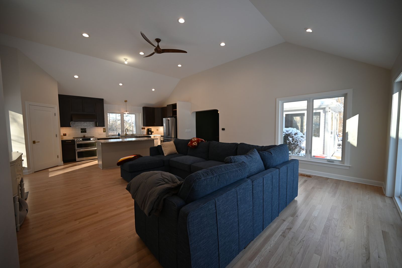 Living room with a sectional open to the kitchen in the Ann Arbor remodel