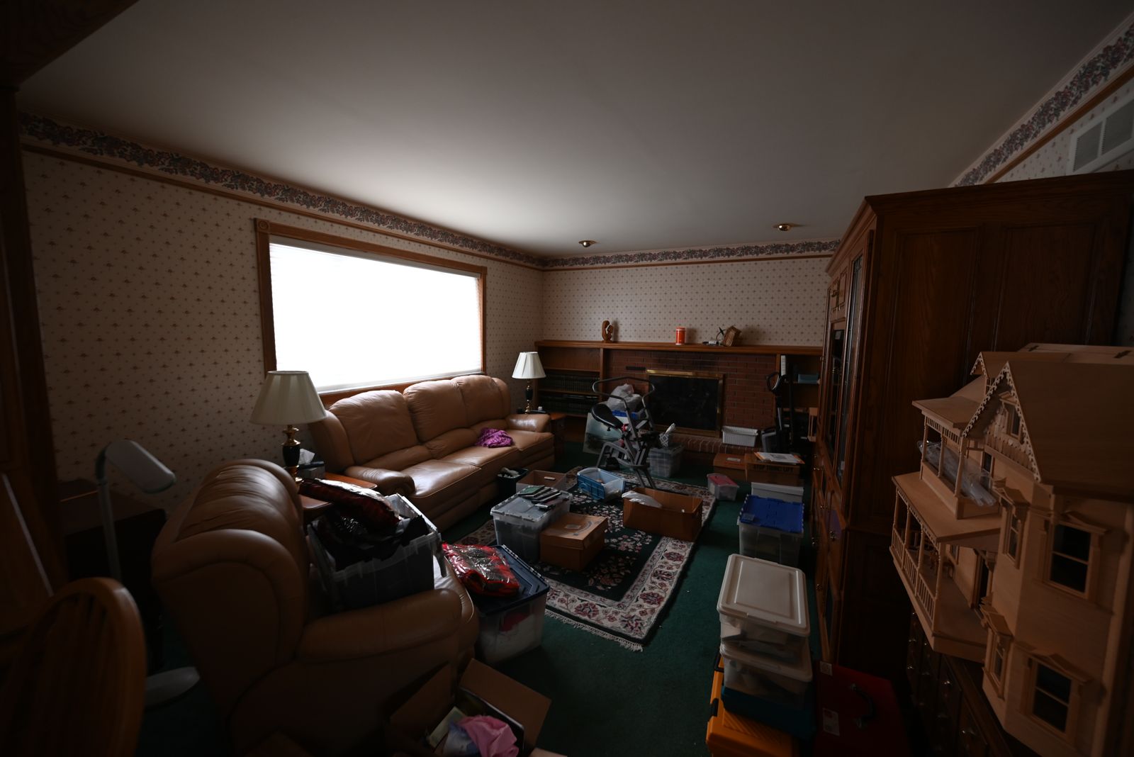 Dated, wallpapered living room in the Canton home before the remodel