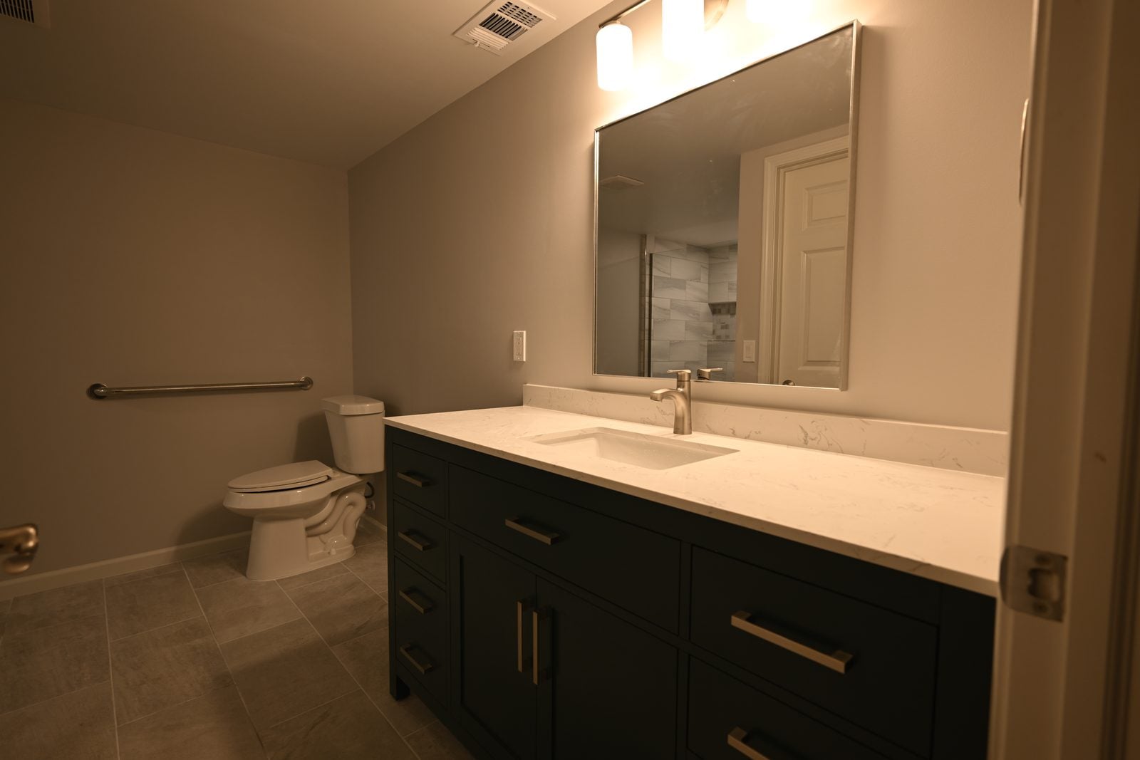 Remodeled Plymouth basement bathroom with a green vanity and a walk-in shower