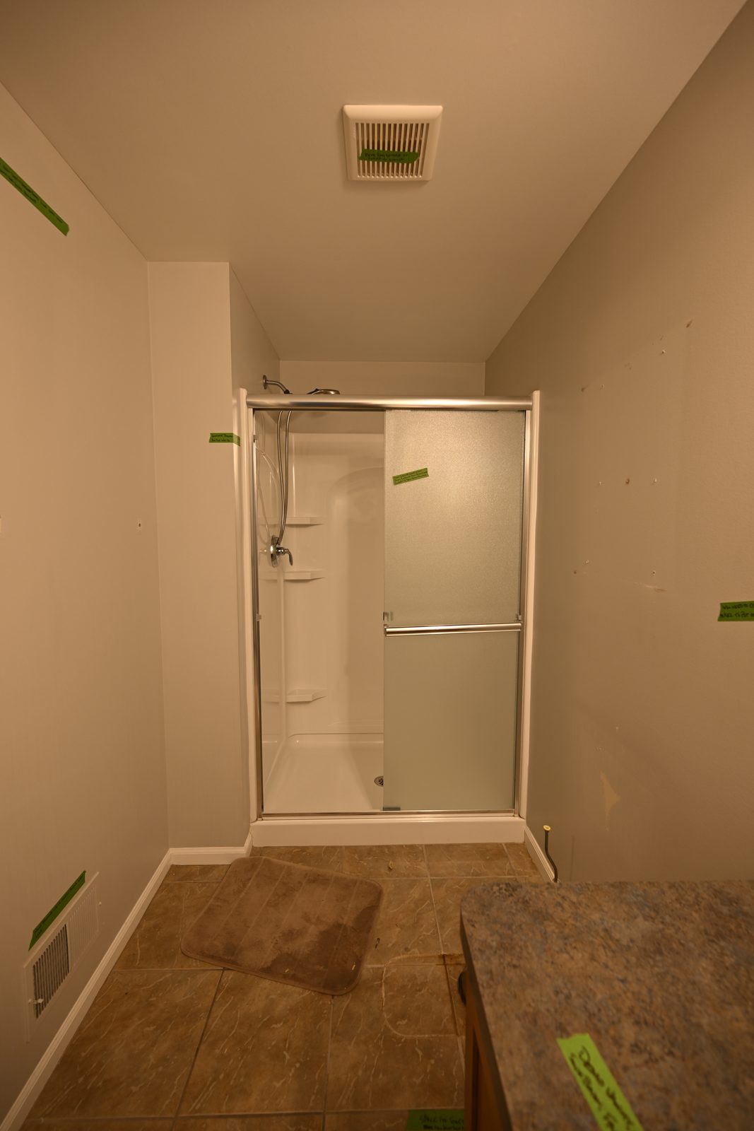 Plymouth basement bathroom before the remodel with a framed sliding-door shower stall