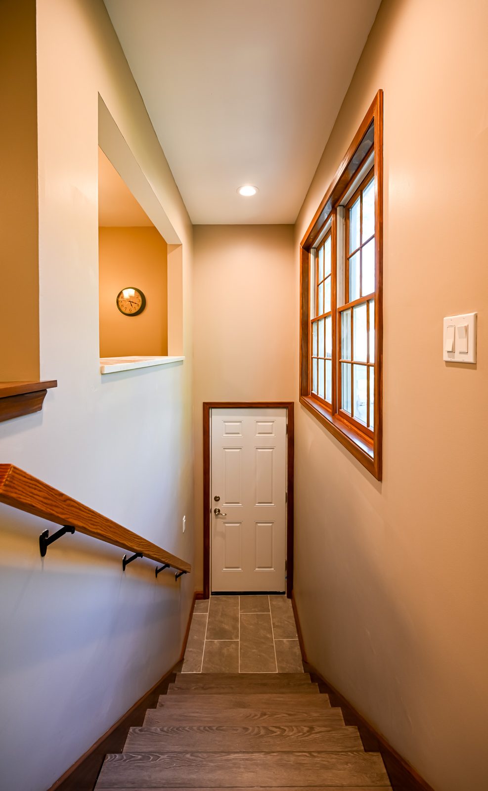 Mudroom entry in Saline with coat hooks, stained wood trim and large-format tile flooring