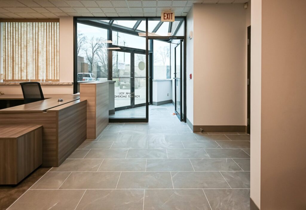Renovated reception area in a Troy title office with a wood desk, tile floor and glass entry vestibule