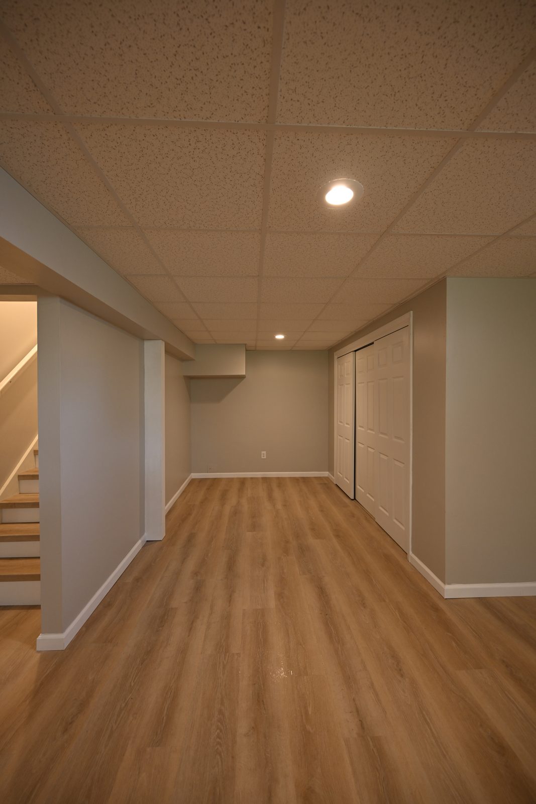 Basement nook with a closet door, recessed lighting and new plank flooring in Ypsilanti