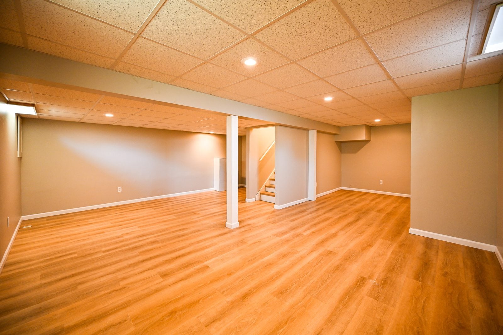 Refinished Ypsilanti basement with a drop ceiling and wood-look plank flooring