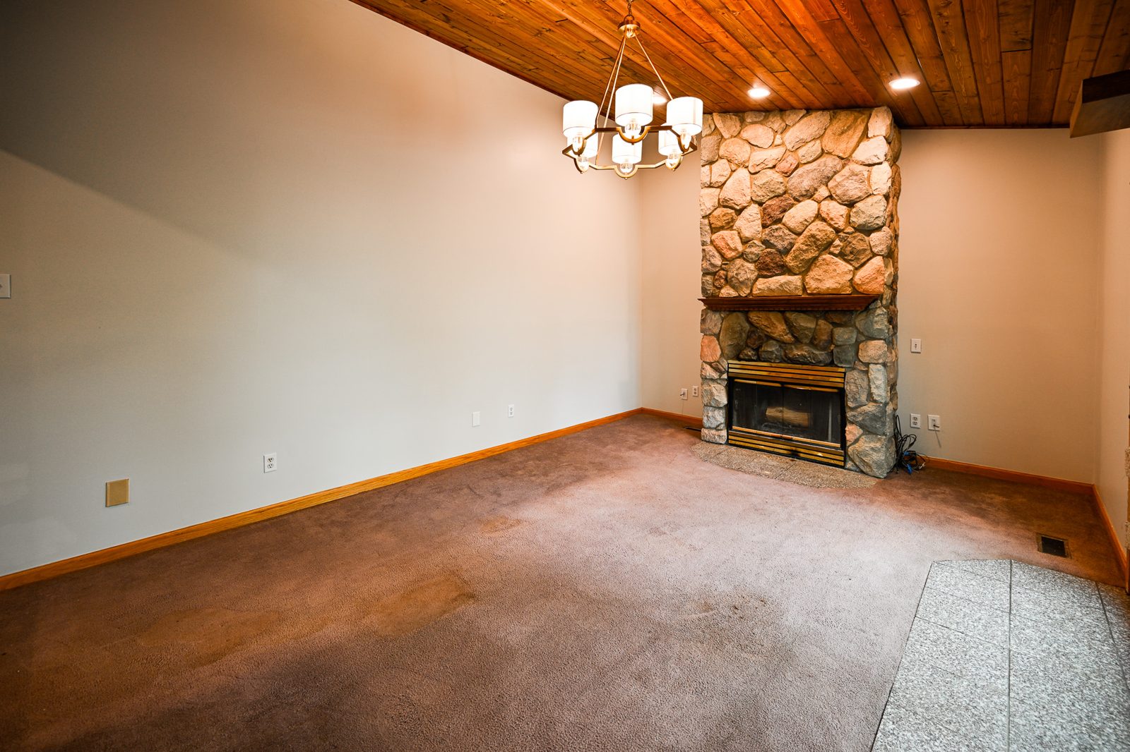 Freshly painted walls and new lighting around the stone fireplace in an Ypsilanti living room