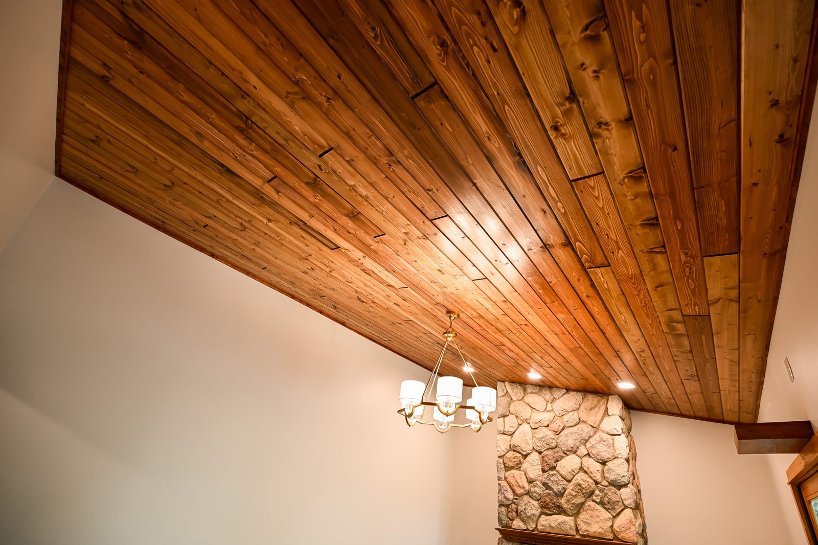 Sweep of the new tongue-and-groove pine ceiling with a chandelier in Ypsilanti
