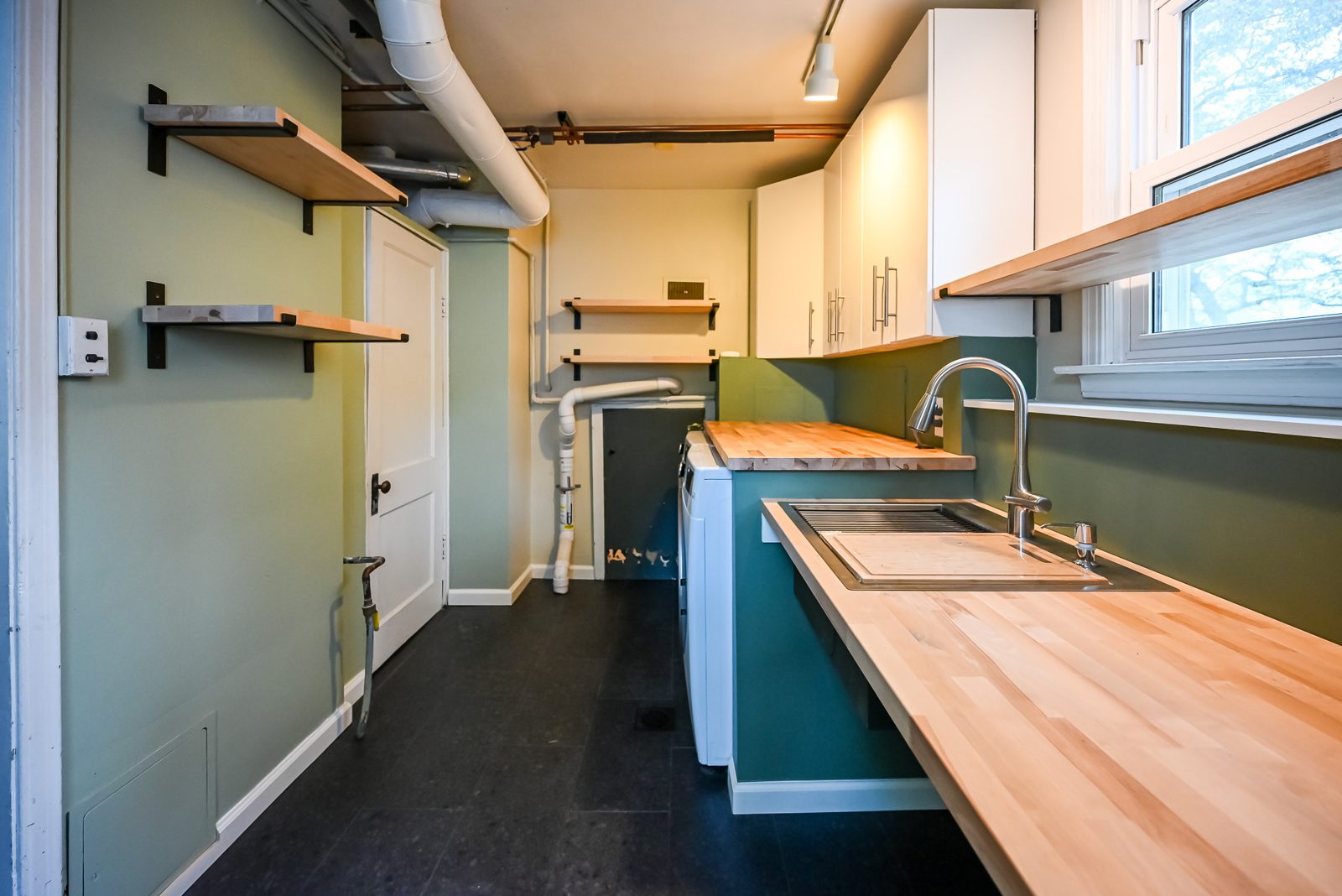 Open bracketed shelving and a long birch counter in a remodeled Ypsilanti mudroom