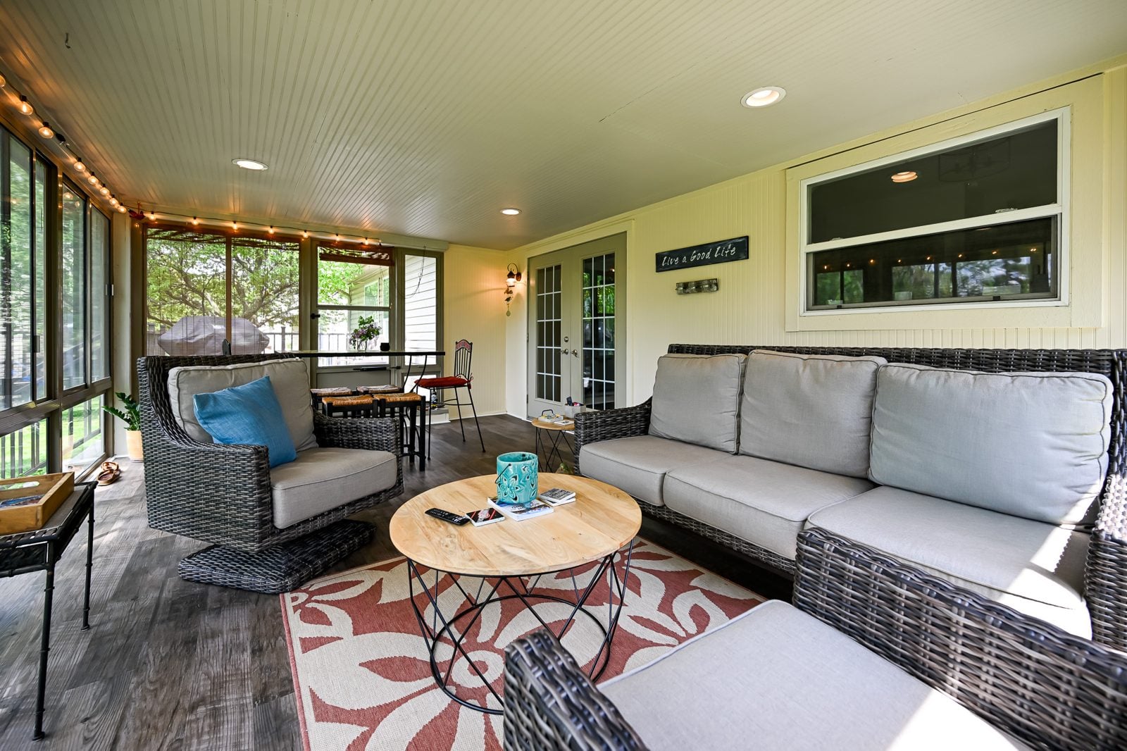 Remodeled three-season porch in Ypsilanti with new vinyl plank flooring and wicker seating