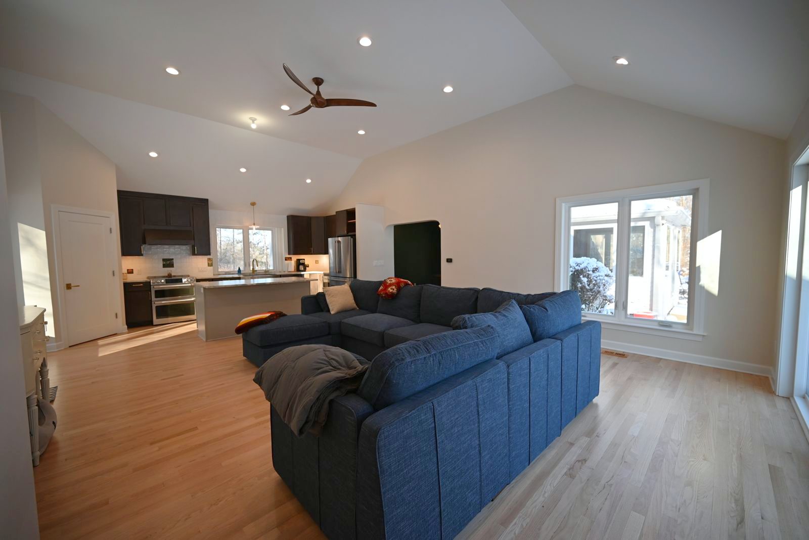 Living room with a sectional open to the kitchen in the Ann Arbor remodel