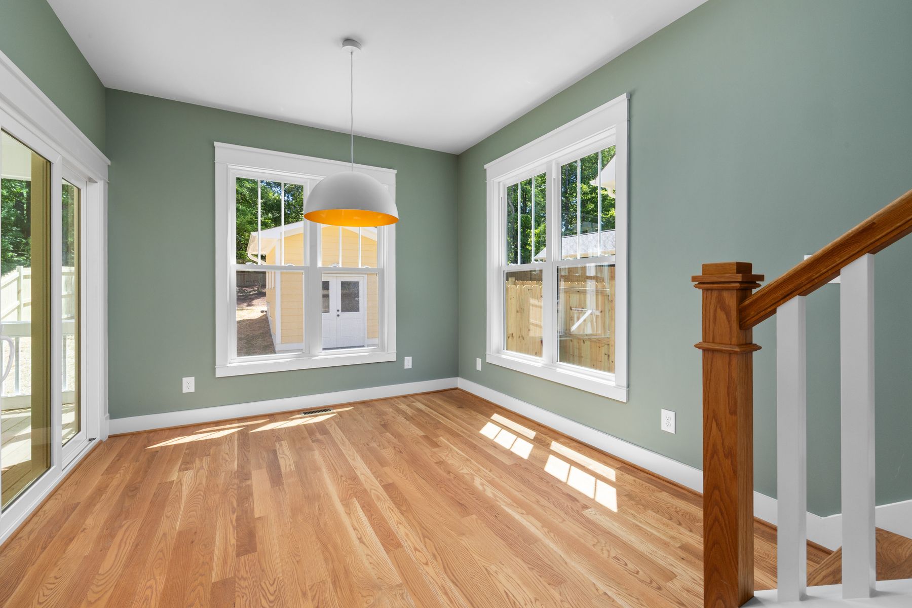Empty room with freshly finished walls, white trim and a hardwood floor