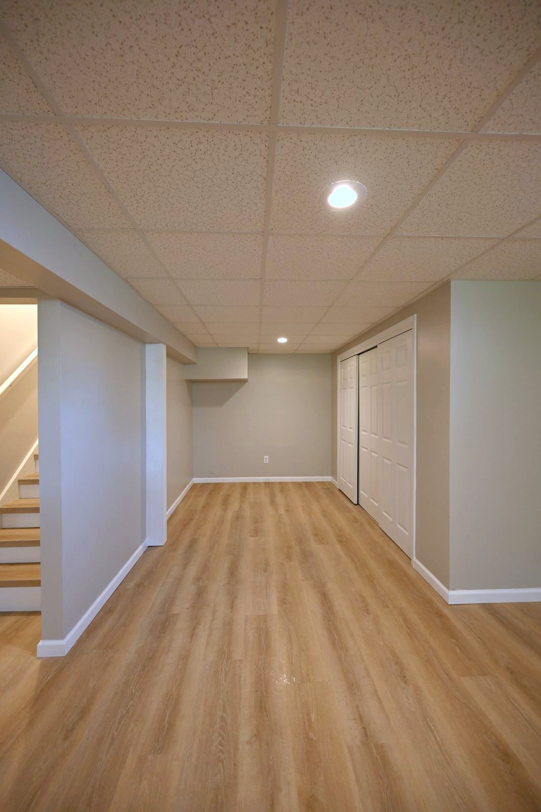 Basement nook with a closet door, recessed lighting and new plank flooring in Ypsilanti