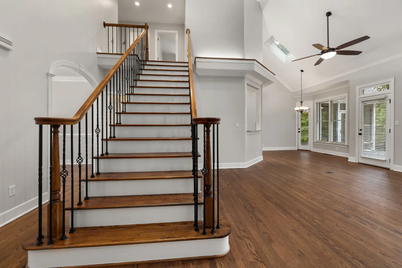 Staircase with a stained wood handrail and black iron balusters