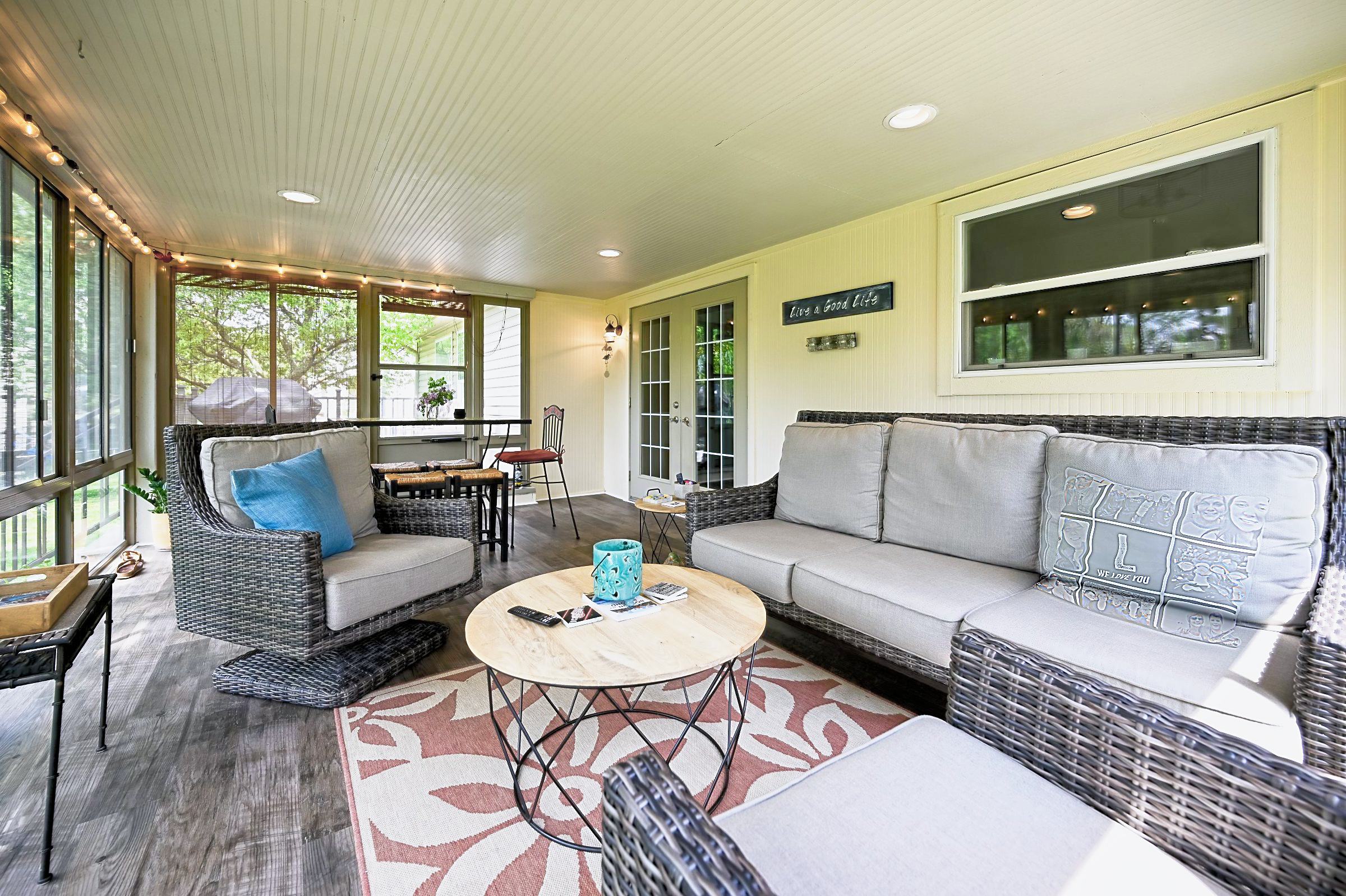 Remodeled three-season porch in Ypsilanti with new vinyl plank flooring and wicker seating